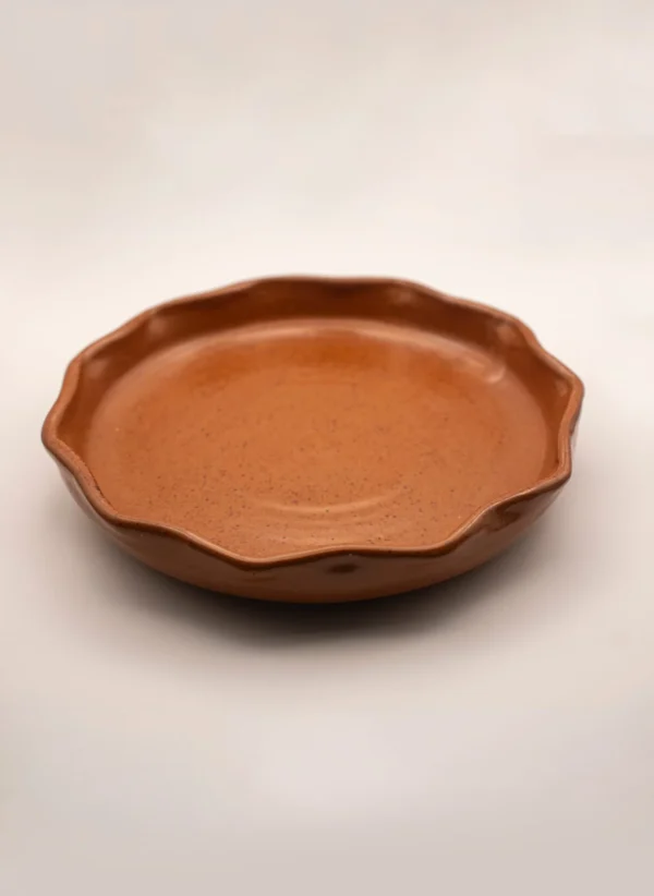 Plato de cerámica con forma orgánica en tonos terrosos, ideal para emplatados gastronómicos.