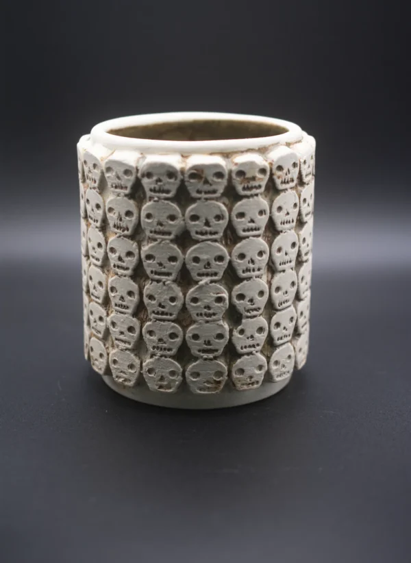 Vaso de cerámica artesanal con relieves de calaveras, inspirado en los tzompantlis mexicas.