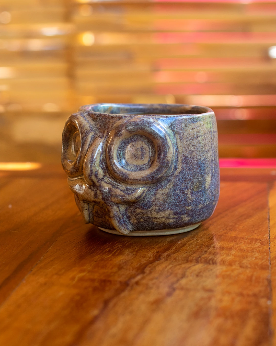 Taza de cerámica artesanal con rostro de Tláloc, esmalte tipo galaxia en tonos marrones y azulados.